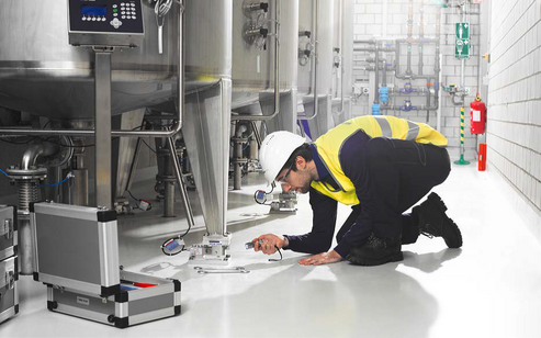 Load cell technician inspecting weighing measurements